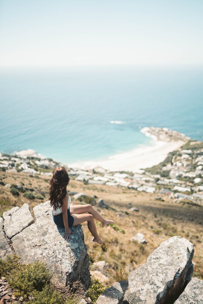 services-02 Woman enjoying a panoramic ocean view from a cliff in Cape Town, South Africa.