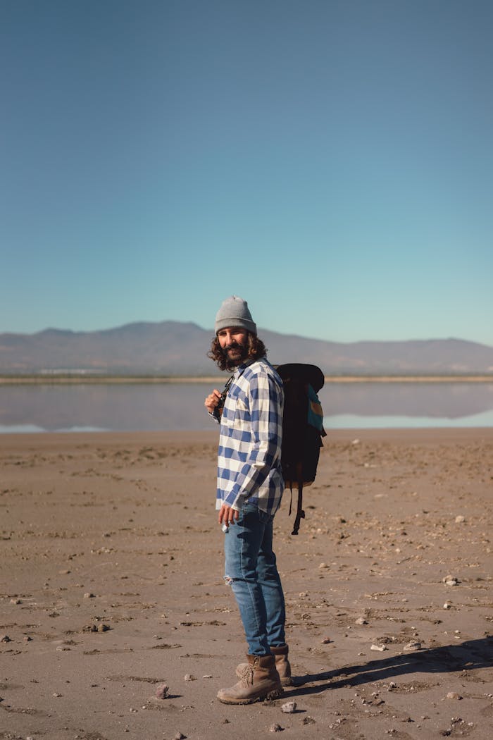 our-story Outdoor photo of a man backpacking on a rocky beach, capturing lifestyle and travel vibes.